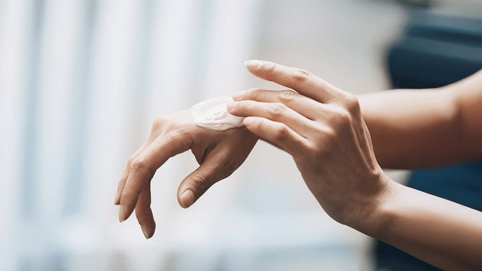 Immagine che raffigura una donna che spalma una crema sulle mani