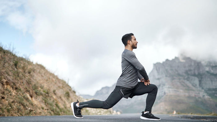 Immagine di un uomo che fa stretching in montagna