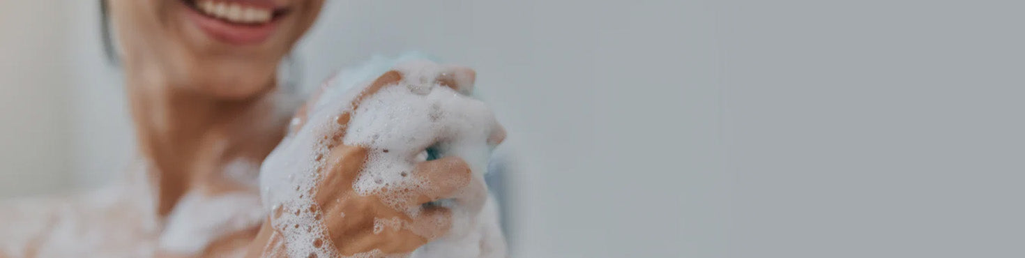 Immagine che raffigura una donna che si lava con un detergente